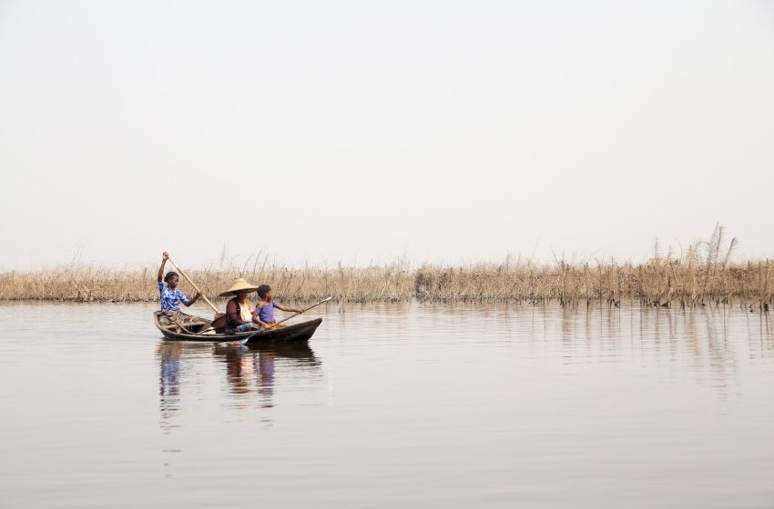 man riding on blue boat on body of water during daytime