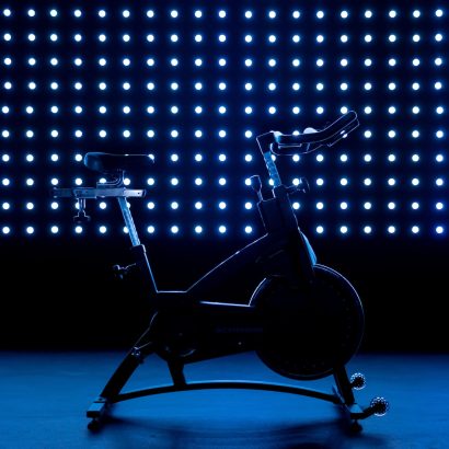 a stationary exercise bike in front of a blue background